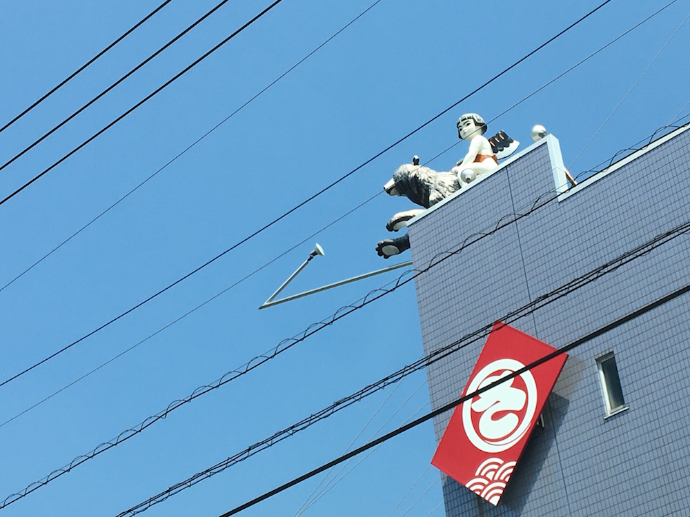 ビルの上で店の看板の役割をする「金太郎」。熊にまたがる姿が愛らしい