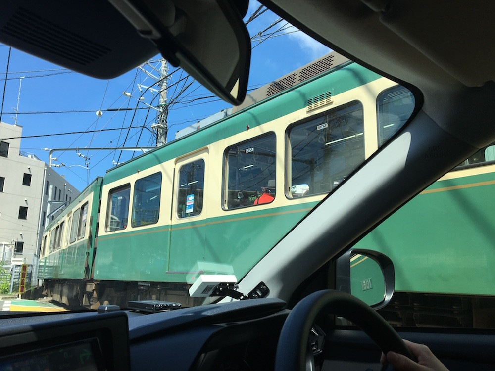 目の前を通る江の島電鉄(通称:江ノ電)。ゆっくり進むスピードにほっこりさせられる