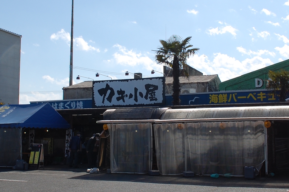 カキ小屋を運営する飯岡屋水産は、明治29年創業の老舗海産物問屋。セルフサービスなので、食事は自分で取りに行き、食べ終わったら食器を片づける