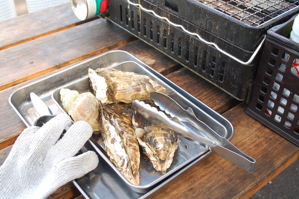 「ガンガン焼き」1,000円(税込み)の内容は、大きなカキ3つとバイ貝。セットの内容は日によって替わる。トングや手袋も貸してくれる