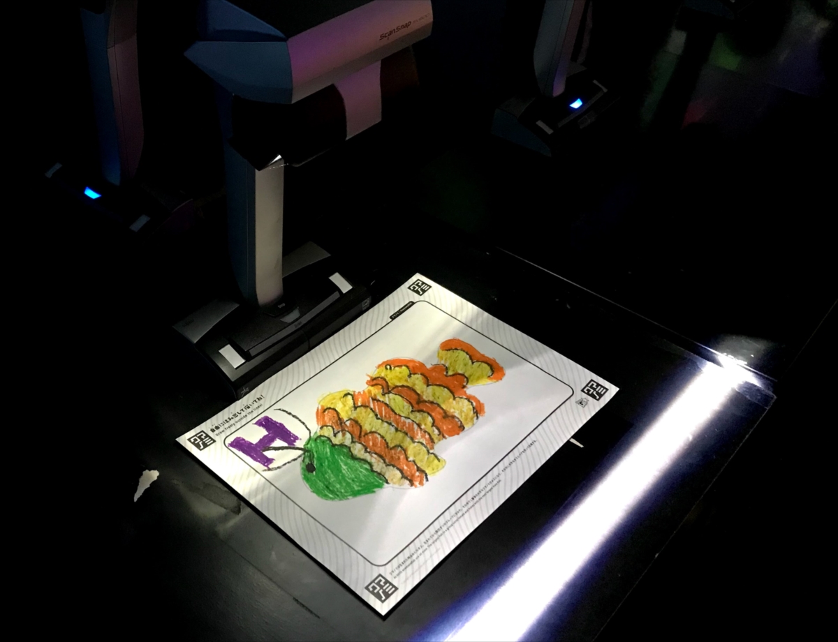 描いた絵をスキャンしてスクリーンに映し出される様子も近くで見られる