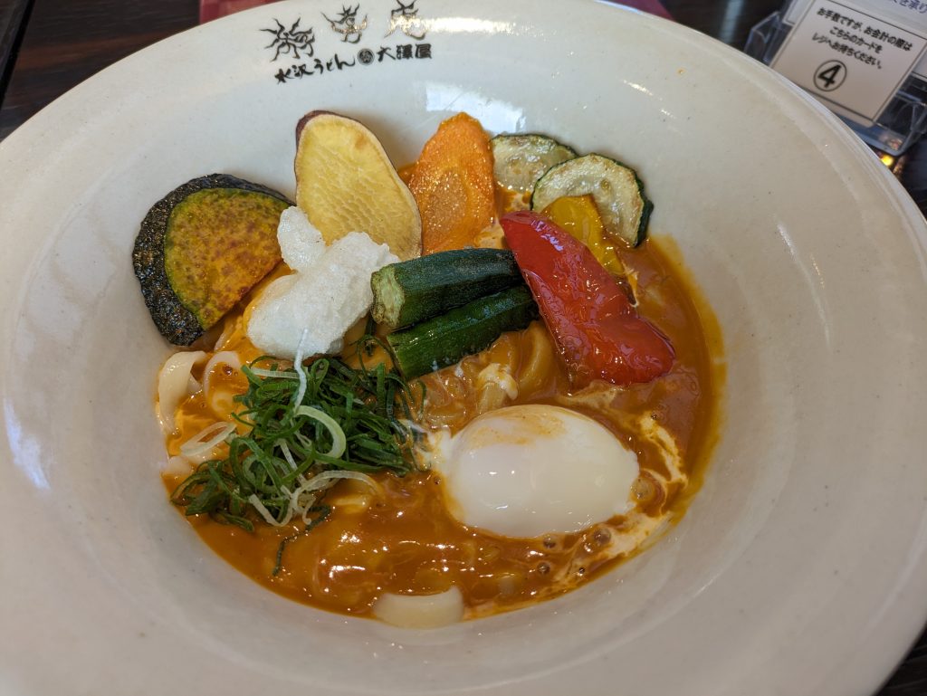 揚げ野菜はかぼちゃ、さつまいも、にんじん、ズッキーニ、おくら、パプリカ。そしてお餅と温泉卵がトッピングされた盛り盛りメニュー「辛辛お得並セット」1,580円(税込み)