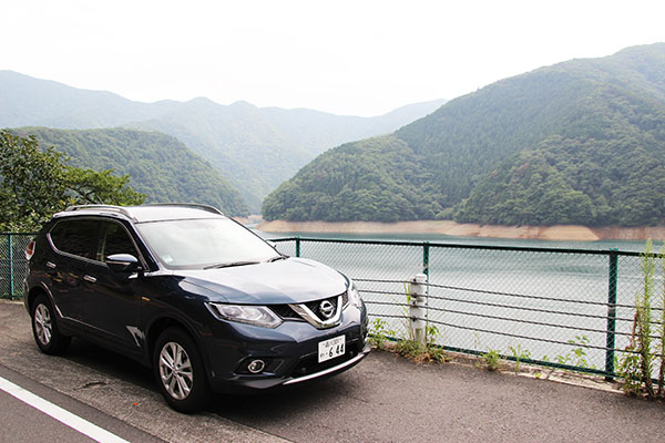 奥多摩湖を背景に記念撮影。今回の相棒はニッサン・新型エクストレイルでした
