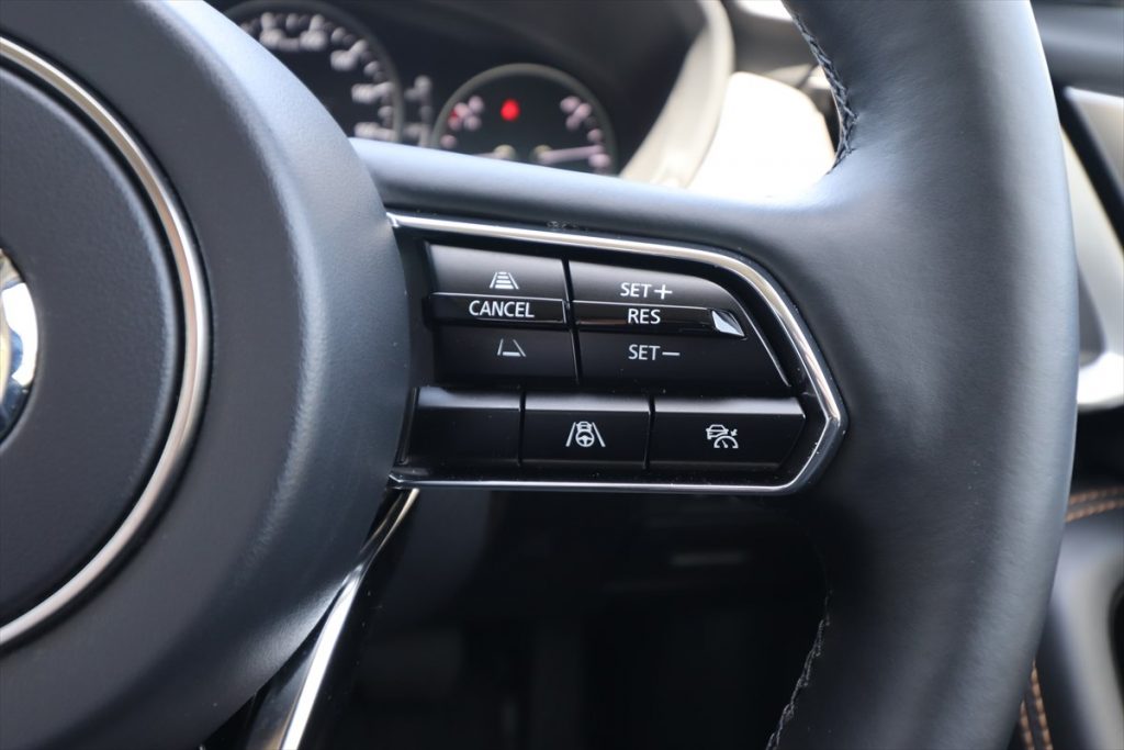 写真はマツダ「CX-60」。CANCELスイッチの上と下は、ACC作動時の車間を調整するもの
