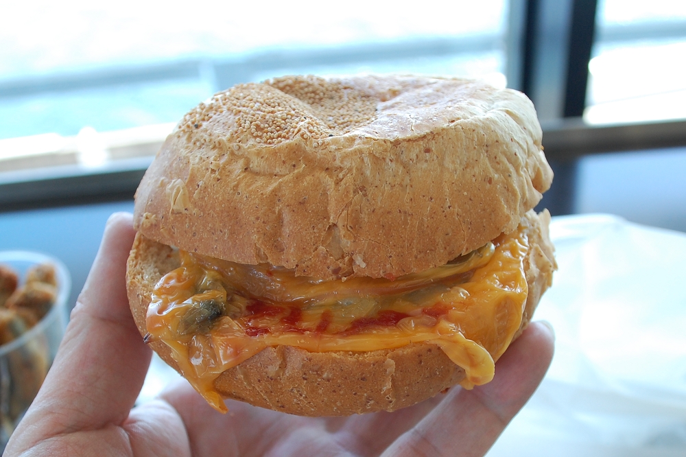 「木更津あさりバーガー」350円(税込み)。ぎっしりとあさりがつまっており、こぼれないようチーズが使用されている