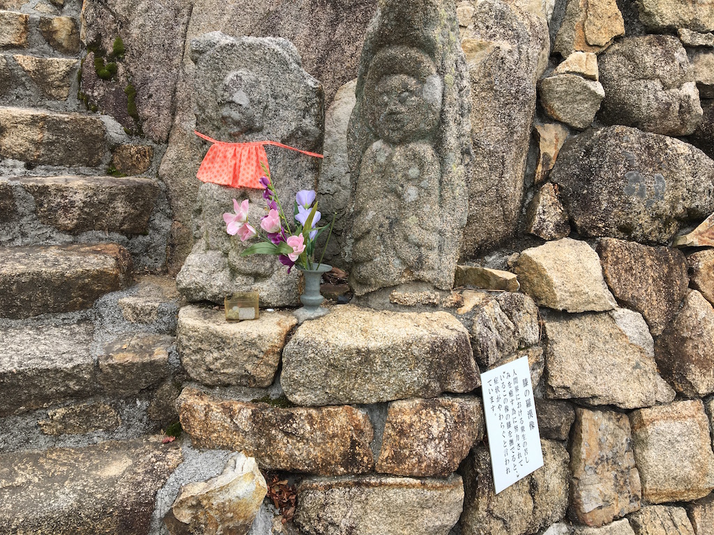 「膝の羅漢像」。左の石仏の膝を撫でると、抱えている苦しみの症状がやわらぐといわれている