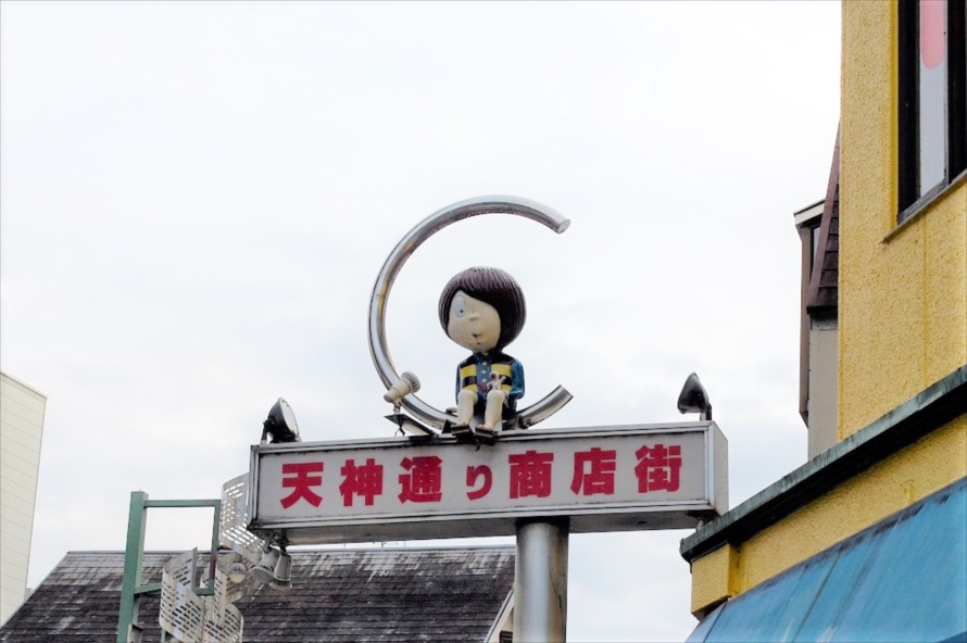 天神通りの両端にある街灯の上で、鬼太郎は通行人をながめている