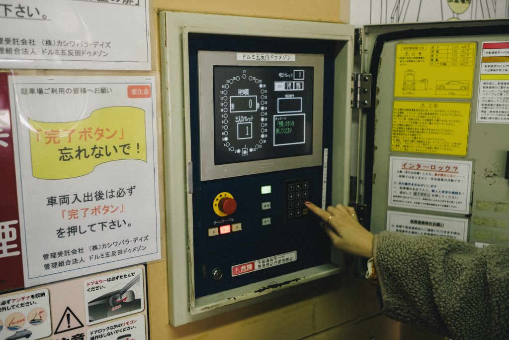 出発地点は「五反田駅前第1」。一般ビルの立体駐車場を利用したステーションで、パネルの操作が必要。予約メールに書かれている暗証番号を入力し、クルマを受け取る