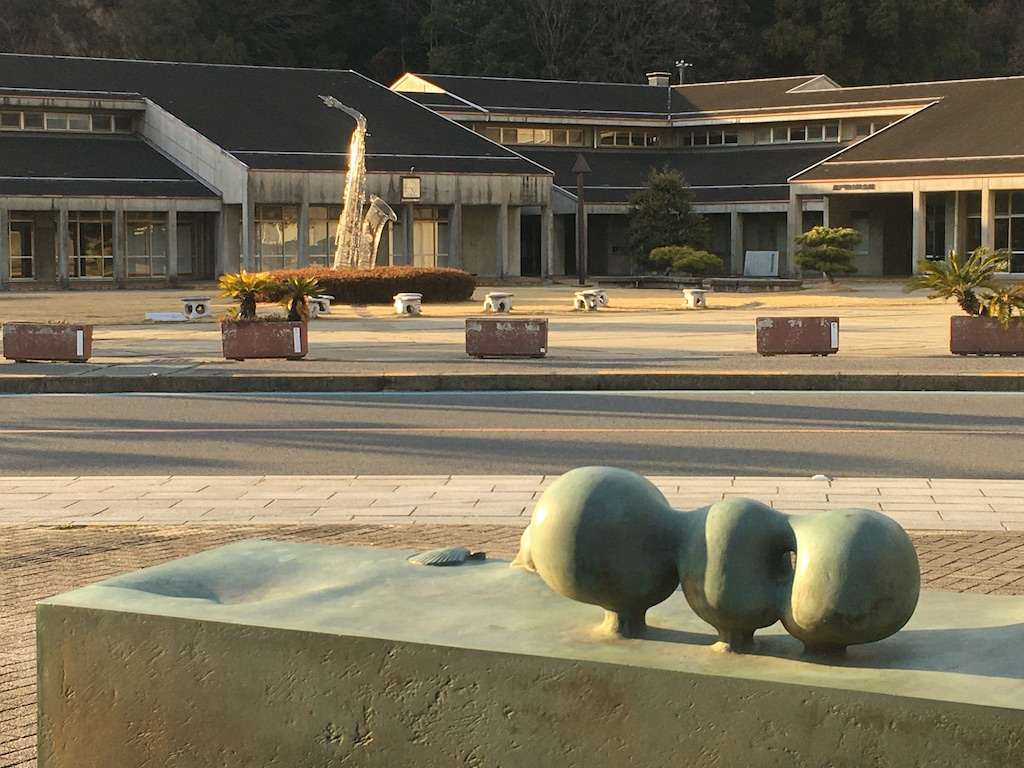 手前のオブジェが、「海からの贈り物（山本正道 作）」。奥の大きなサックスの作品は、「風の中で（西野康造 作）」