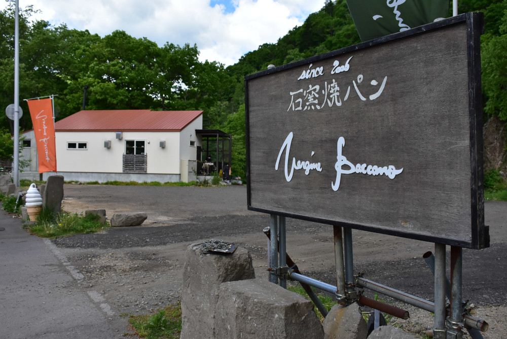 大きな山をバックにぽつりと立つパン屋「ヴェルジネバッカーノ」