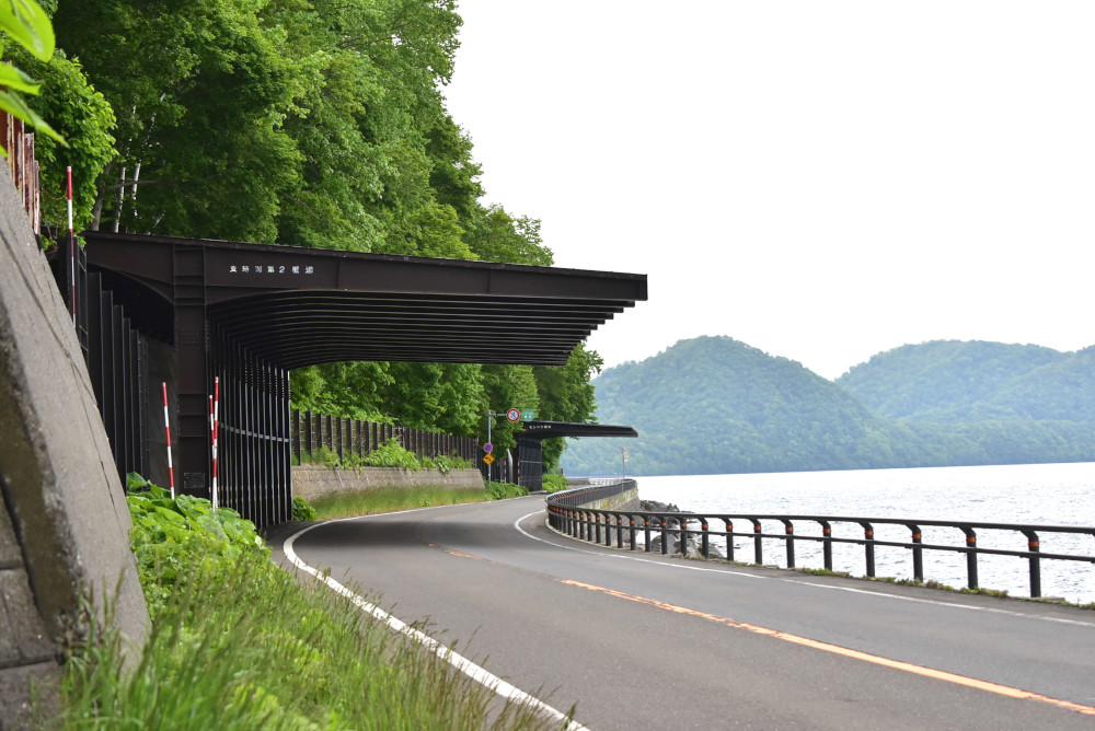 湖沿いギリギリを通る道路。落石防止の覆道が連なる