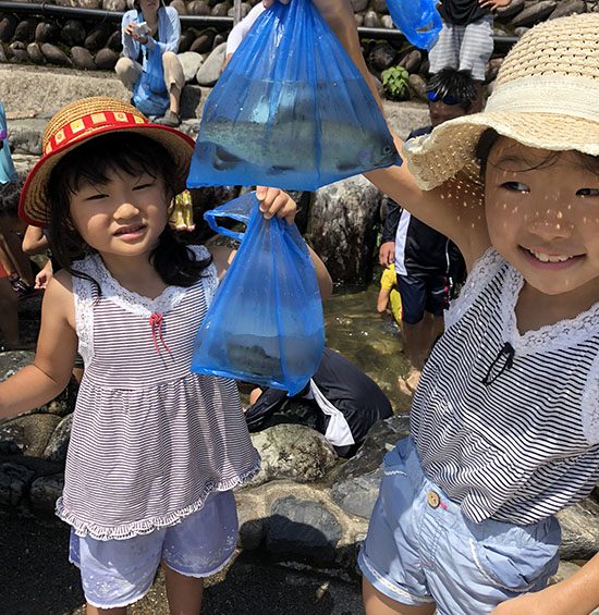 大きなニジマスを手に入れて笑顔