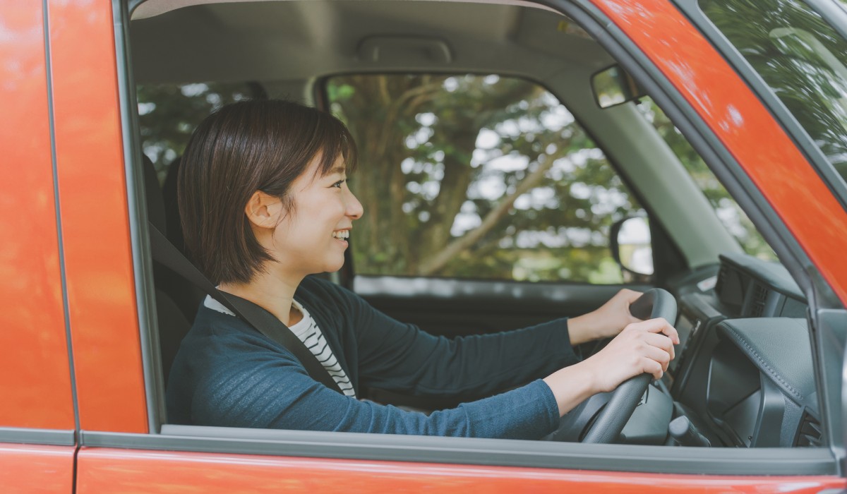 コンパクトカーでドライブを楽しむ人