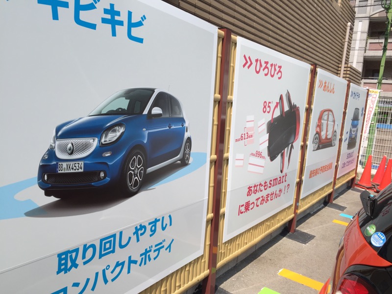 クルマの背面の竹垣には、スマートの特徴を紹介するパネル看板があります
