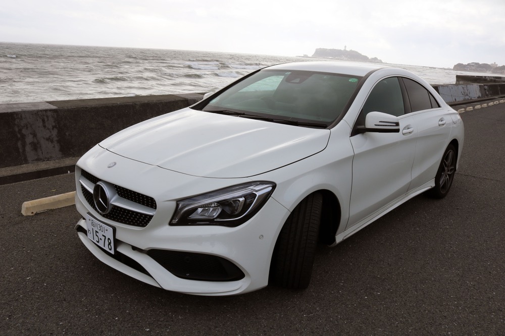 江の島と湘南の海をバックに、CLA180CoupeSportsのクールなフロントグリル・デザインが映える